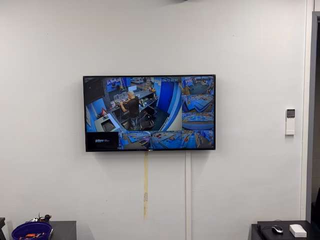 CCTV monitor on the office wall showing the live camera views